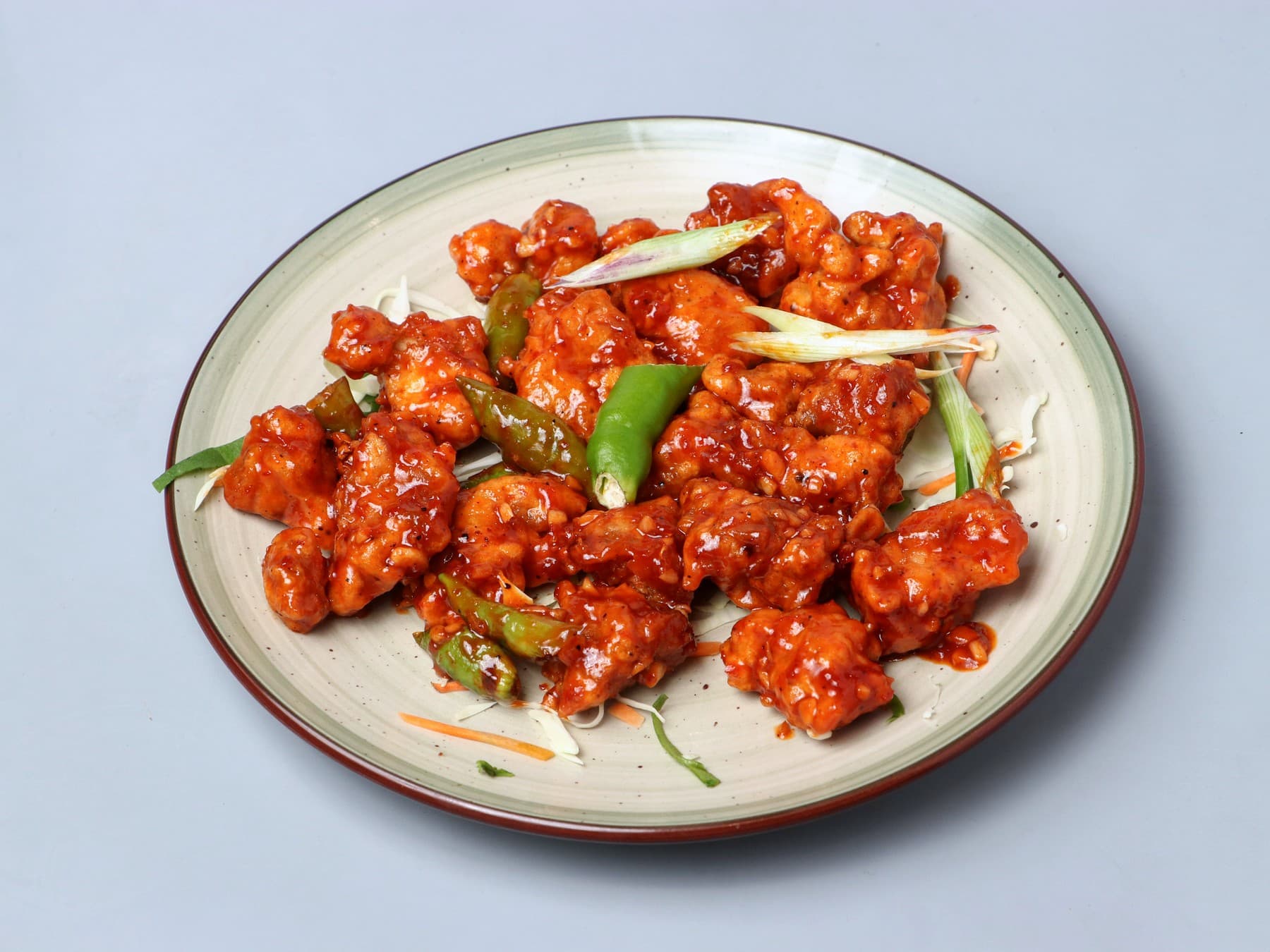 Glossy chilli garlic chicken with green chillies and spring onion