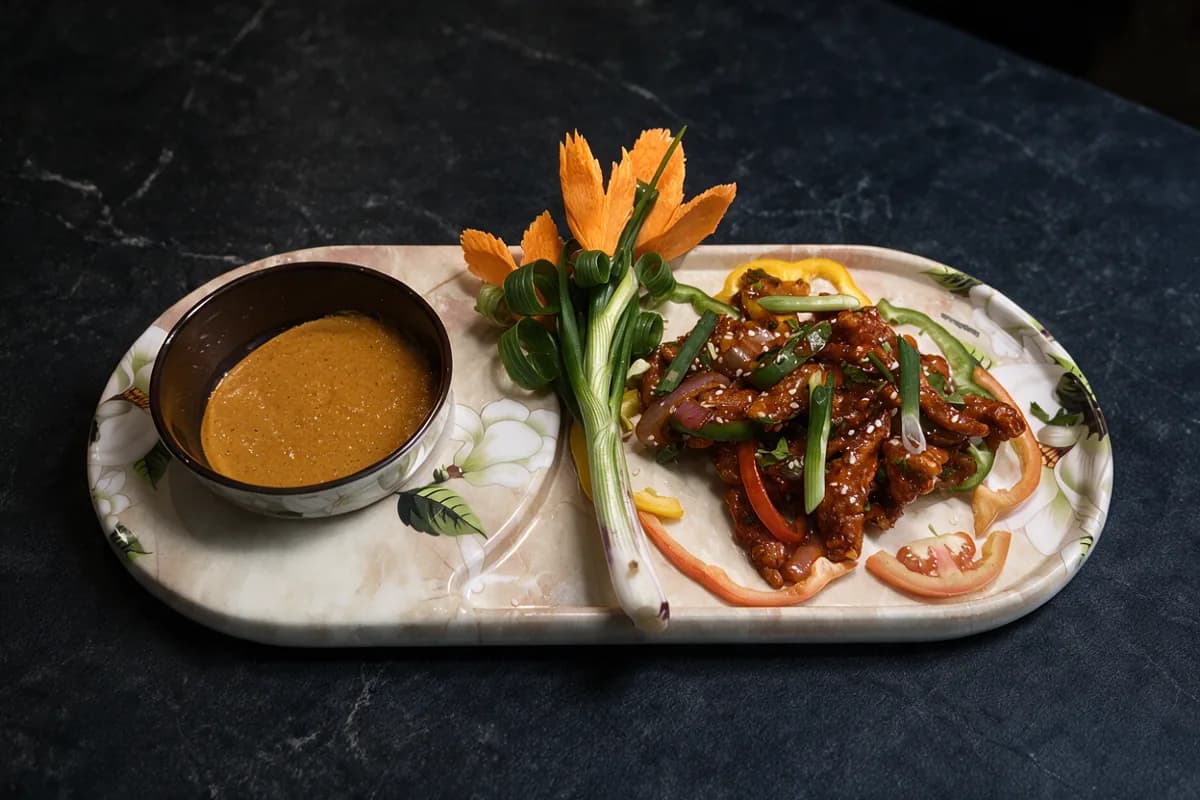 Crispy Tossed Chilli Chicken: crisp strips in a glossy chilli glaze with sesame