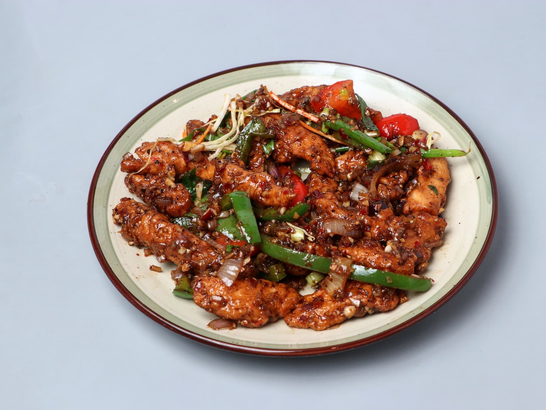 Dark-glazed pepper chicken strips with capsicum