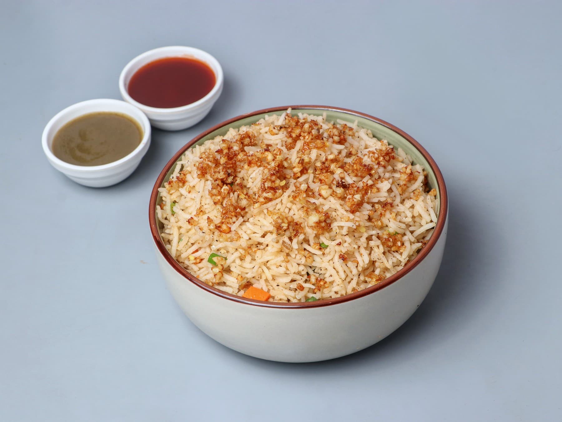 Fried rice topped with crisp ginger and garlic, with two dips