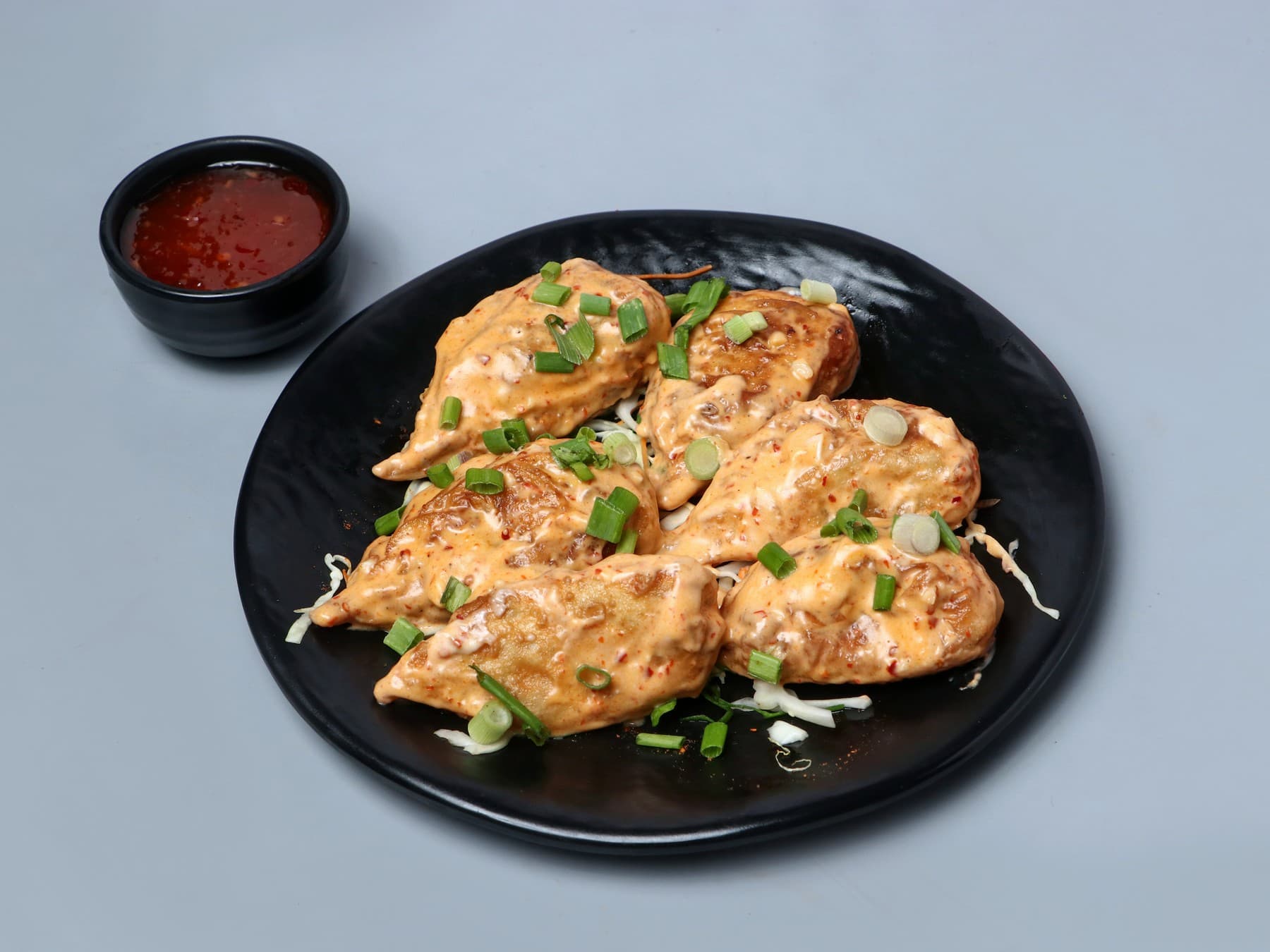 Veg margherita momos with a golden cheese topping and a chilli dip